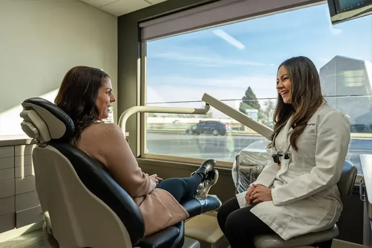 Family First Dental dentist smiling and consulting with a patient in the treatment room