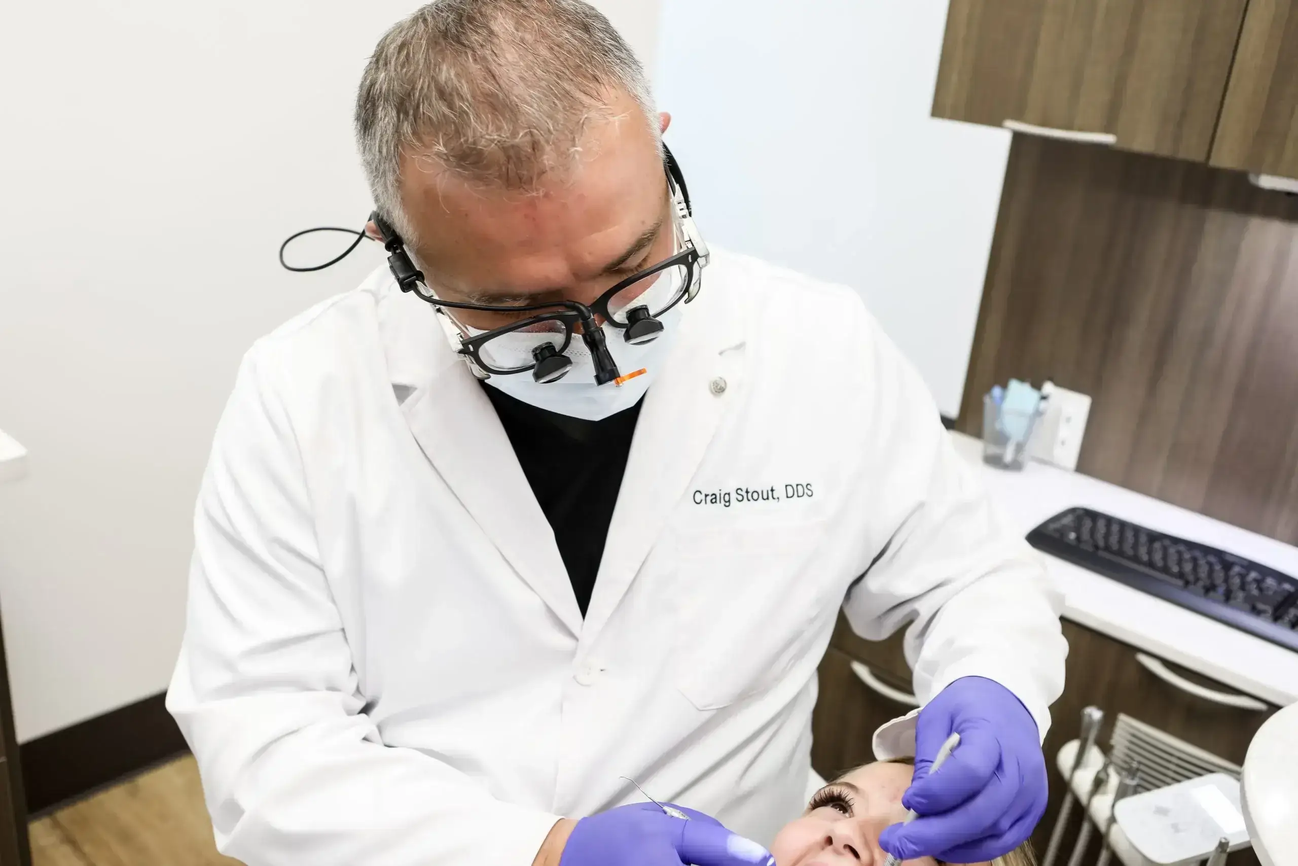 Family First Dental dentist wearing loupes and gloves performing a dental procedure on a patient.