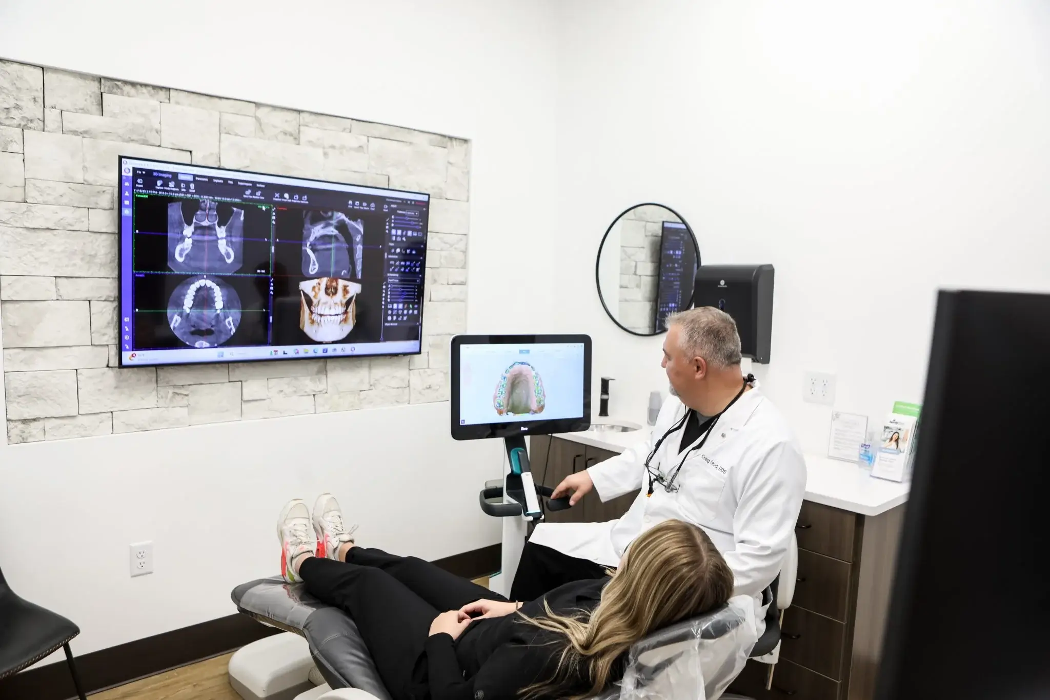 Dentist reviewing 3D CBCT imaging and digital scan results with a patient at Family First Dentist.
