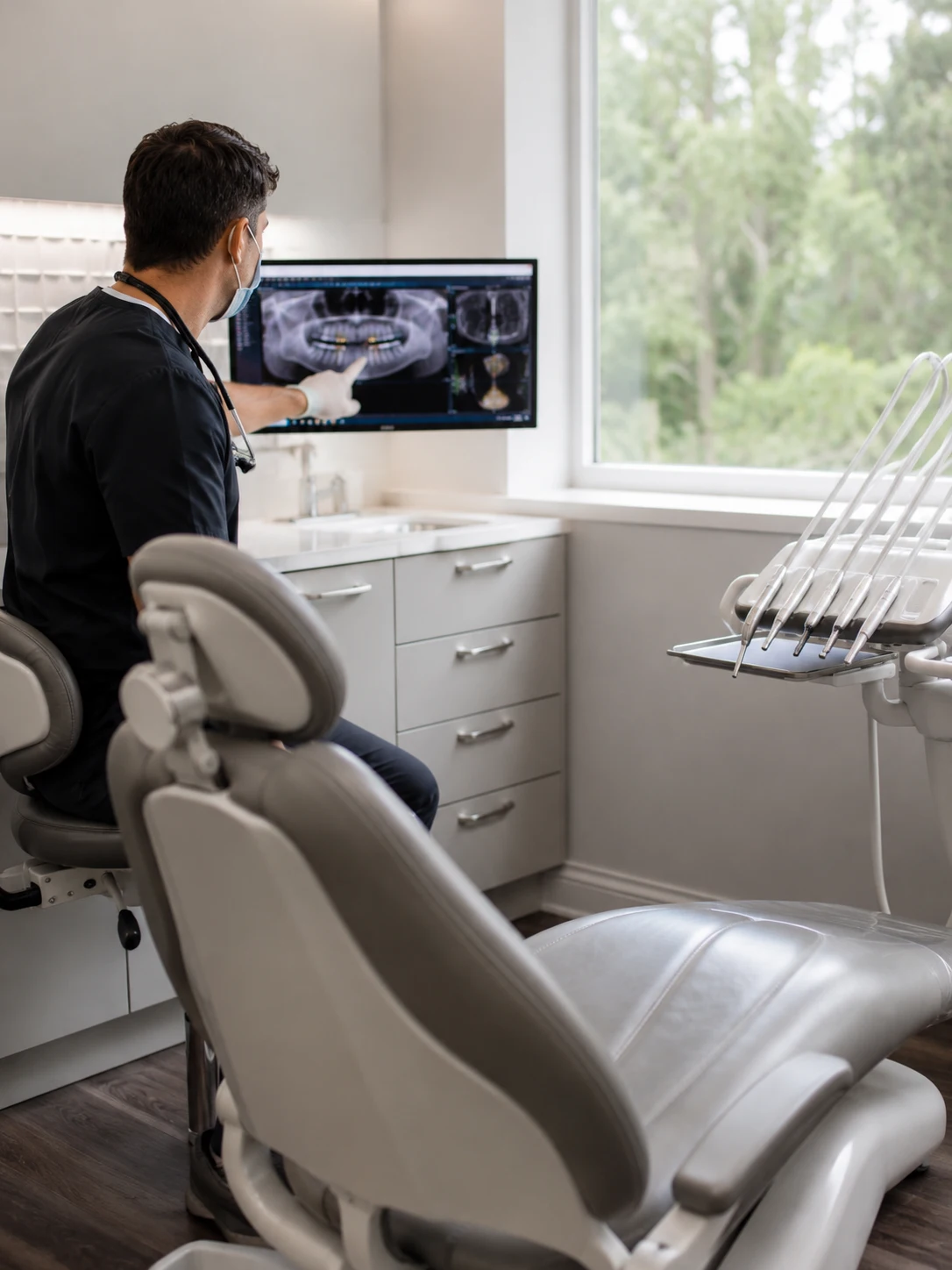 Modern dental exam room with implant imaging displayed during a consultation